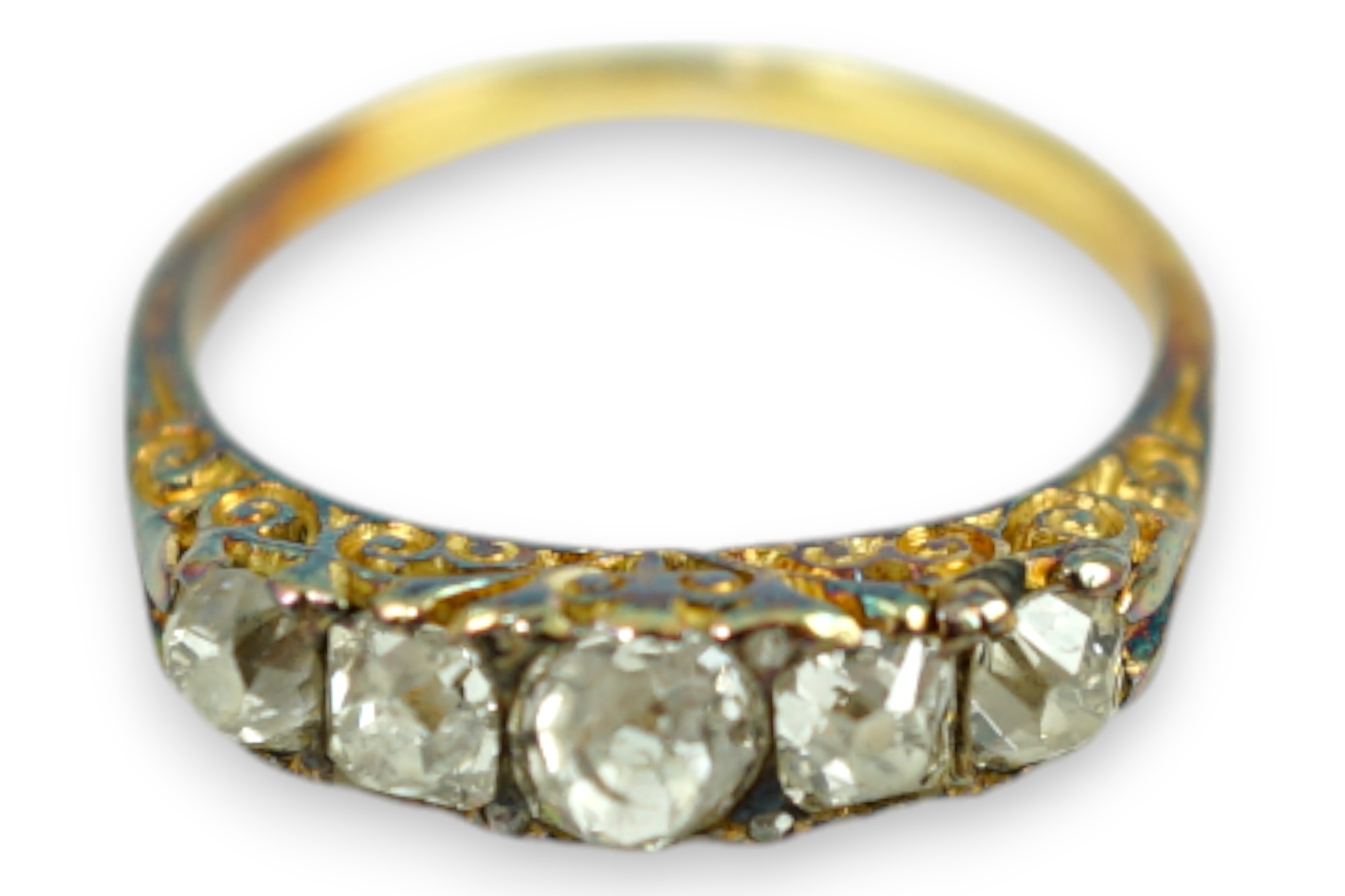 An early 20th century yellow metal and graduated five stone old round cut diamond set half hoop ring, with diamond chip spacers, size K, gross weight 2.8 grams.